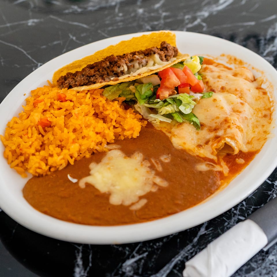 A white plate with a hard-shell taco, rice, refried beans, and two cheese enchiladas.