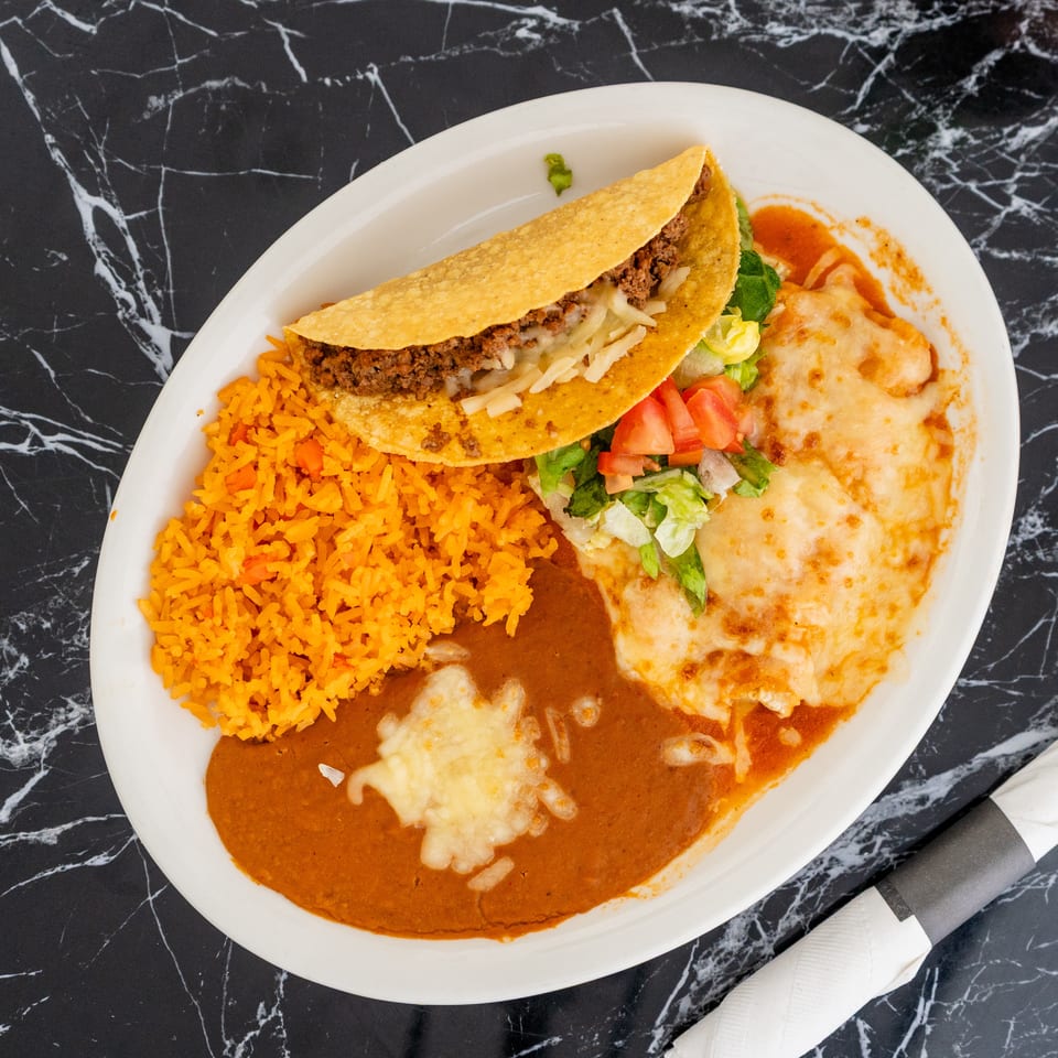 A Mexican combination plate with a taco, rice, refried beans, and two cheese enchiladas.